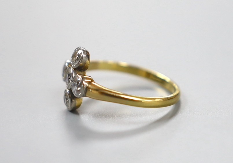 An 18ct and collet set five stone diamond 'cross' ring, size O, gross weight 3 grams.